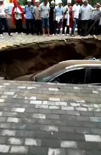 路面塌陷小车坠坑后却围满戴孝人？